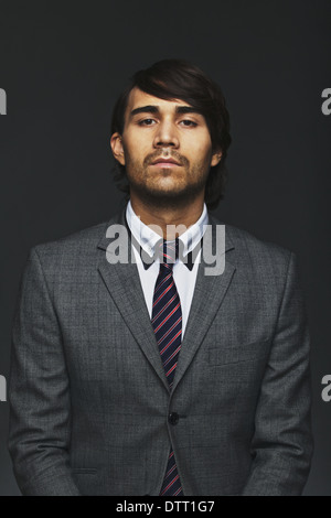 Portrait of young businessman looking at camera. Homme d'affaires en litige isolé sur fond noir. Banque D'Images