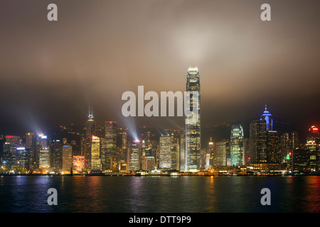 La nuit au bord de l'eau longue Hong lasers avec la projection de rayons lumineux dans une brume d'hiver brun's sky au show laser nocturne Banque D'Images
