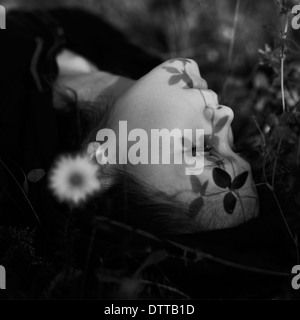 Caucasian girl laying in grass Banque D'Images