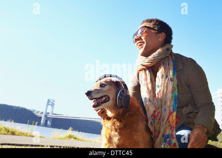 Black woman and dog relaxing in park Banque D'Images