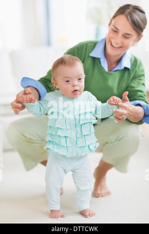 Caucasian mother helping bébé avec le Syndrome de marche Banque D'Images