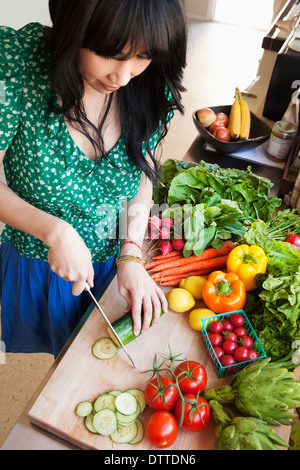 Woman chopping vegetables in kitchen Banque D'Images