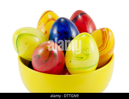 Les oeufs de pâques en céramique dans le bol jaune sur un fond blanc. Banque D'Images