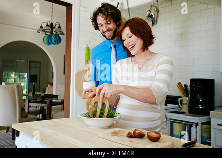Femmes enceintes Caucasian couple cooking in kitchen Banque D'Images