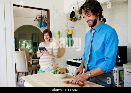 Femmes enceintes Caucasian couple cooking in kitchen Banque D'Images