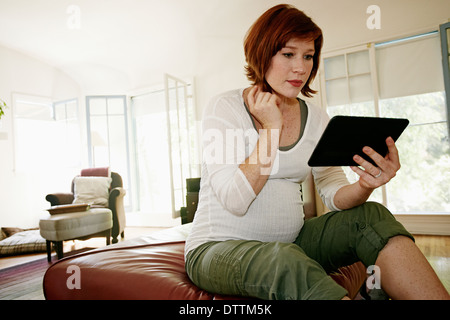 Femmes enceintes Caucasian woman using digital tablet Banque D'Images