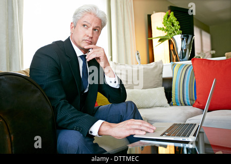 Caucasian businessman travaillant dans la salle de séjour Banque D'Images