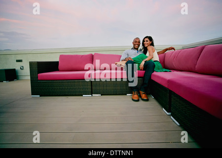 Couple relaxing on sofa outdoors Banque D'Images