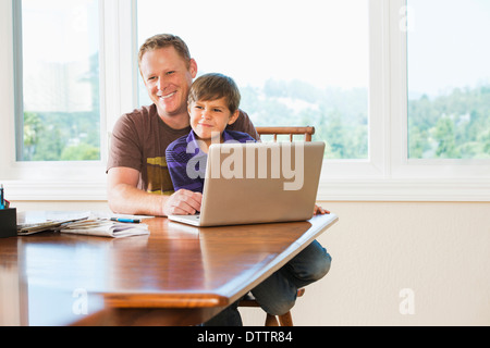 Père et fils using laptop together Banque D'Images