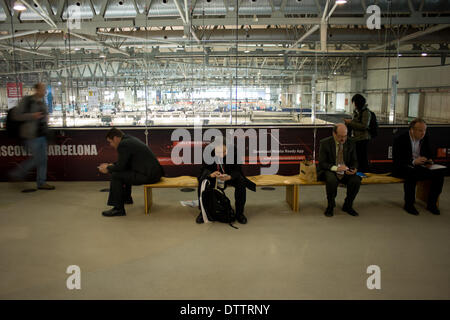 L'Hospitalet (Barcelone), Espagne - 24 Février, 2014. Les gens regarder son téléphone à l'exposition, qui héberge le MWC.Le Mobile World Congress 2014 ouvre ses portes avec une fréquentation de 75 000 visiteurs attendus. Crédit : Jordi Boixareu/Alamy Live News Banque D'Images