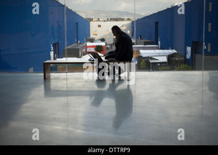 L'Hospitalet (Barcelone), Espagne - 24 Février, 2014. Un homme travaille sur son portable au MWC. Le Mobile World Congress 2014 ouvre ses portes avec une fréquentation de 75 000 visiteurs attendus. Crédit : Jordi Boixareu/Alamy Live News Banque D'Images