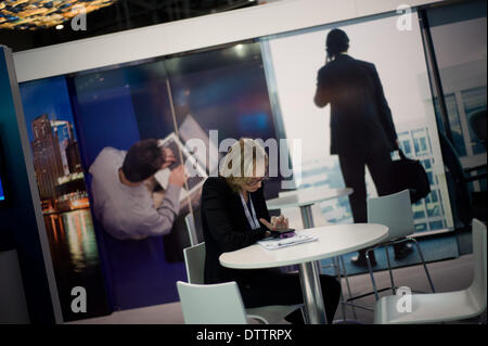 L'Hospitalet (Barcelone), Espagne - 24 Février, 2014.Une femme regarde son téléphone à l'exposition, qui héberge le MWC. Le Mobile World Congress 2014 ouvre ses portes avec une fréquentation de 75 000 visiteurs attendus. Crédit : Jordi Boixareu/Alamy Live News Banque D'Images