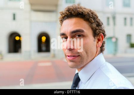 Hispanic businessman on city street Banque D'Images