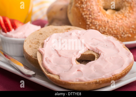 Bagel sésame fraîchement préparés avec du fromage à la crème aux fraises, jus d'orange et fraises mûres Banque D'Images