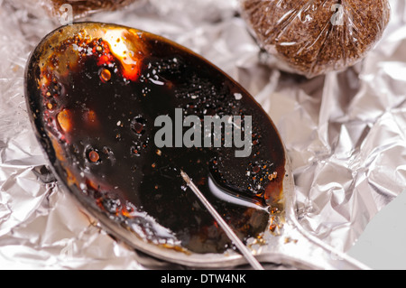 En utilisant une aiguille pour aspirer l'héroïne cuit à partir d'une cuillère sale Banque D'Images