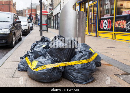 Le déversement illégal de sacs de déchets. Scène de crime Enviro bande fixée. Les décharges sauvages de déchets dans une rue de Sheffield, England, UK Banque D'Images