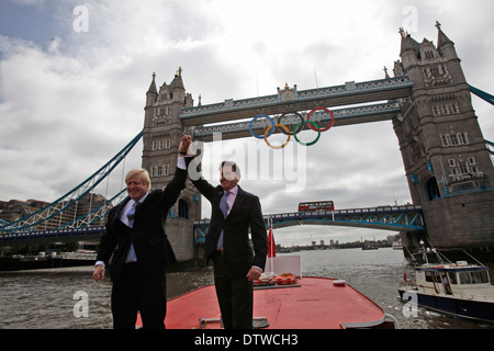 Maire de Londres Boris Johnson (L) et Lord Sebastian Coe, le président du comité d'organisation de Londres des Jeux Olympiques, cheer comme un gigantesque ensemble d'anneaux olympiques sont affichées de Tower Bridge le 27 juin 2012 à Londres, en Angleterre. Les anneaux pèse plus de trois tonnes et mesurer plus de 25 mètres de large par 11,5 mètres de hauteur ; ils s'allume une lumière-show chaque soir pendant les Jeux. Banque D'Images