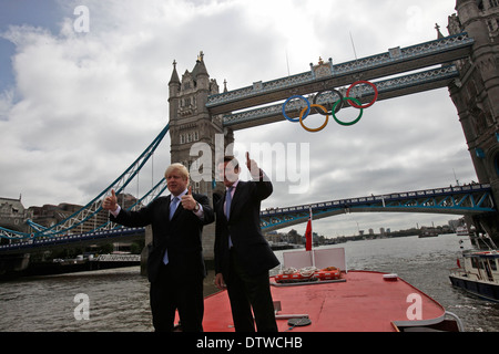 Maire de Londres Boris Johnson (L) et Lord Sebastian Coe, le président du comité d'organisation de Londres des Jeux Olympiques, cheer comme un gigantesque ensemble d'anneaux olympiques sont affichées de Tower Bridge le 27 juin 2012 à Londres, en Angleterre. Les anneaux pèse plus de trois tonnes et mesurer plus de 25 mètres de large par 11,5 mètres de hauteur ; ils s'allume une lumière-show chaque soir pendant les Jeux. Banque D'Images