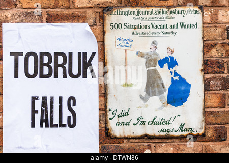 Slogans publicitaire pour les situations vacant le vintage enamel plaque murale à côté de l'affiche de journal de l'époque victorienne. Telford England Banque D'Images