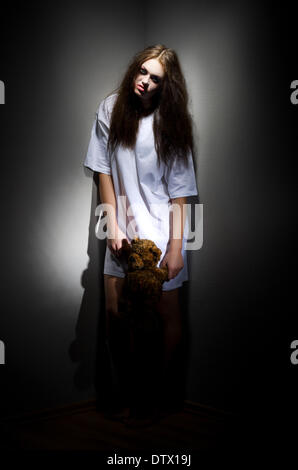 Zombie girl with teddy bear sur noir Banque D'Images