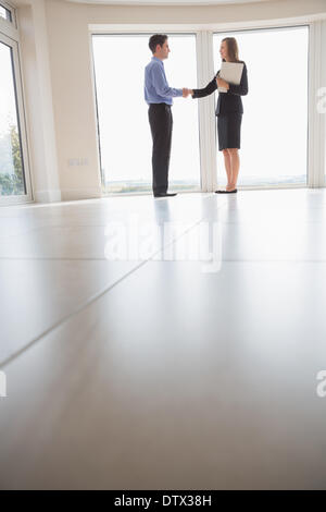 Agent immobilier et man shaking hands Banque D'Images