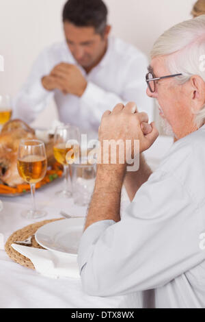 Famille disant grace avant de manger Banque D'Images