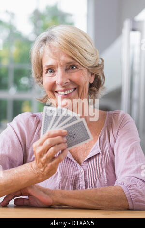 Smiling woman playing cards Banque D'Images