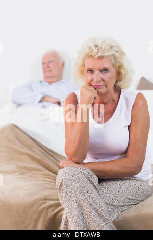 Déçu vieille femme assis Banque D'Images