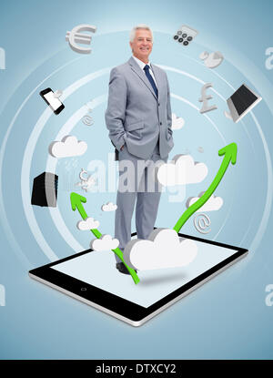 Smiling businessman standing on a tablet pc Banque D'Images