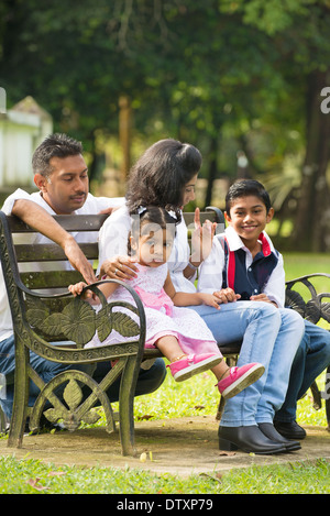 Famille indienne, assis sur le banc dans le parc Banque D'Images