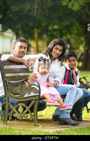 Famille indienne, assis sur le banc dans le parc Banque D'Images