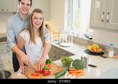 Couple smiling et de travail dans la cuisine Banque D'Images