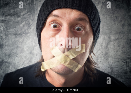 Mes lèvres sont scellées. Casual Man avec capuchon noir avoir tape sur sa bouche. Banque D'Images