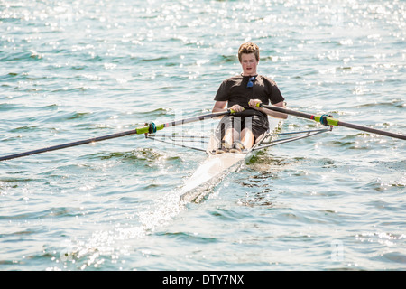 Mixed Race woman rowing on lake Banque D'Images