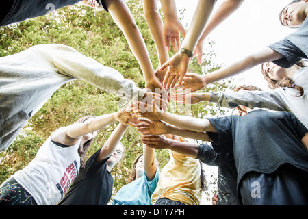 Les adolescents de race blanche mettant les mains ensemble en caucus Banque D'Images