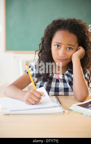 Mixed Race student working in classroom Banque D'Images