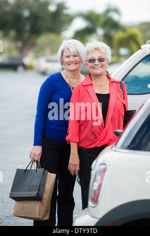 Young women with shopping bags in parking lot Banque D'Images