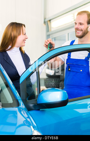 Cliente et mécanicien dans l'atelier automatique ou le mot avec voiture pour inspection de service Banque D'Images