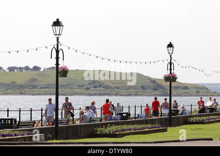 Les gens qui marchent sur la promenade de Largs par l'estuaire de la Clyde en été, North Ayrshire, Scotland, UK Banque D'Images