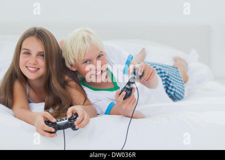 Cheerful siblings playing video games Banque D'Images