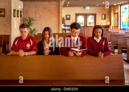 Portrait, asiatique, américain et africain-américain d'étudiants en uniforme prier à une école secondaire privée catholique Banque D'Images