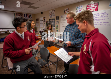 Portrait en uniforme, asiatiques et africains-américains les élèves interagissent avec leur professeur dans un lycée privé catholique. Banque D'Images