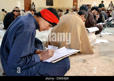 Des élèves du niveau intermédiaire de résoudre les feuilles d'examen au cours de l'examen annuel 2014 à une salle d'examen, en Chaman le Mardi, Février 25, 2014. Banque D'Images