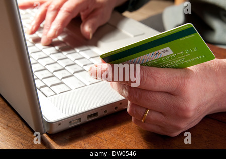 Personne holding credit card using laptop computer Banque D'Images
