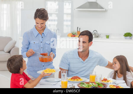 Femme de donner à son fils une sauce pour pâtes Banque D'Images