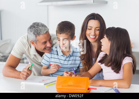 Smiling family drawing together in kitchen Banque D'Images