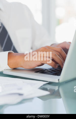 Close up on businessmans hands typing Banque D'Images