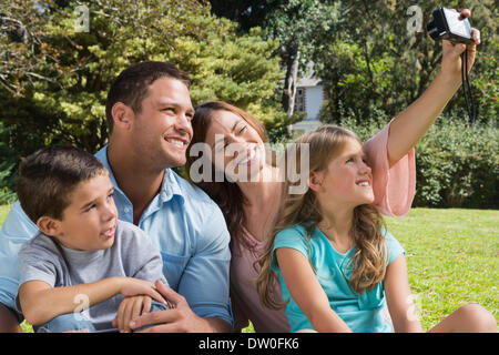 Famille heureuse dans un parc à prendre des photos Banque D'Images