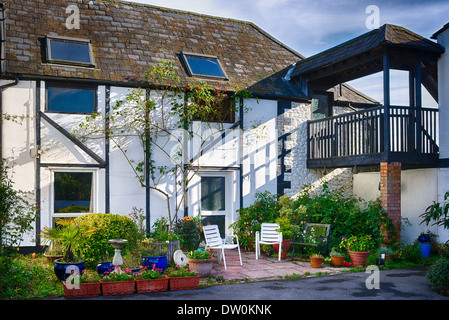 Ancienne grange convertie en usage domestique avec petit jardin patio en UK Banque D'Images