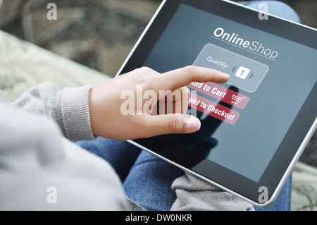 Jeune femme à l'aide d'appareil à écran tactile pour le magasinage en ligne Banque D'Images